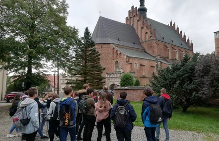 Grupa osób przed zabytkowym kościołem