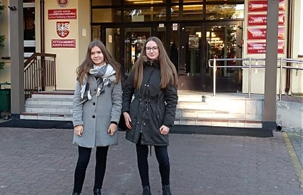 Dwie uczennice przed wejściem do budynku szkoły