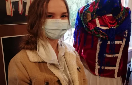 Uczennica przy manekinie ubranym w strój z epoki 