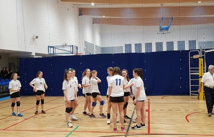 Rozgrzewka na hali sportowej grupy siatkarek szkolnych.