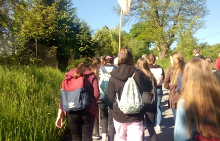 Grupowe zdjęcie uczni&oacute;w na w trakcie wyprawy naukowej, jedna z os&oacute;b trzyma siatkę na owady