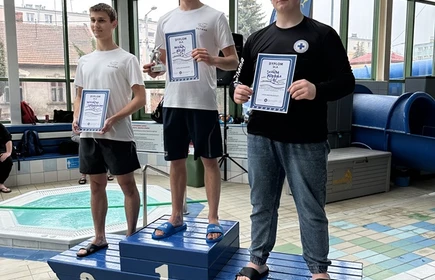 trzech uczniów stojących na podium